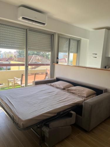 a large bed in a room with a large window at Studio Kialeo près de la plage avec parking voiture in Roquebrune-Cap-Martin
