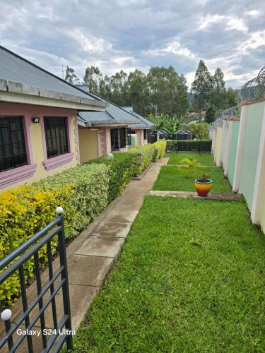 a walkway in a yard next to a row of houses at Finland in Migori
