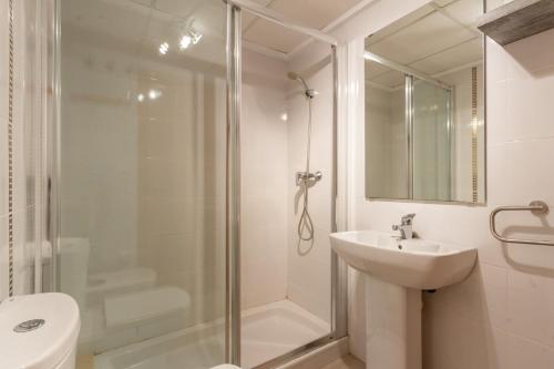 Un baño con ducha, lavabo e inodoro. en Apartamento en El Campello, España, en El Campello