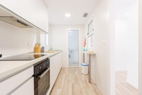 a white kitchen with a sink and a counter at Balcón Mediterráneo - Desconexión a pie de playa in Santa Pola