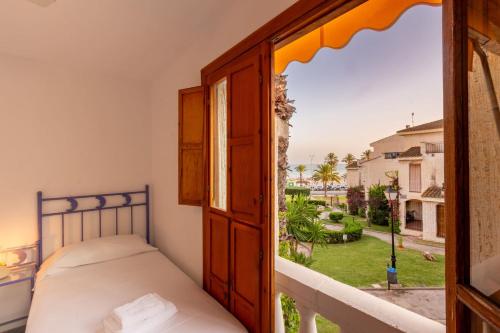 a bedroom with a bed and a view of a yard at Varadero - Bungallow a pie de la playa in Santa Pola