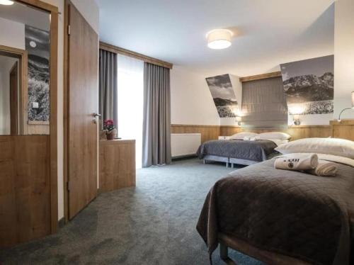 a hotel room with two beds and a window at Pokoje u Nasyj Kasi in Poronin