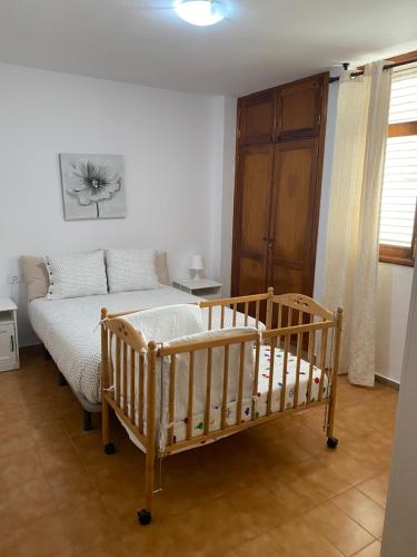 ベガ・デ・サン・マテオにあるCasa de la Plaza San Mateoのベッドルーム(ベビーベッド1台、ベッド1台付)