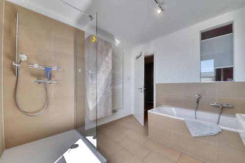 un bagno con doccia, vasca e lavandino di Ferienwohnung Strandgold im Haus Seeblick Binz a Binz