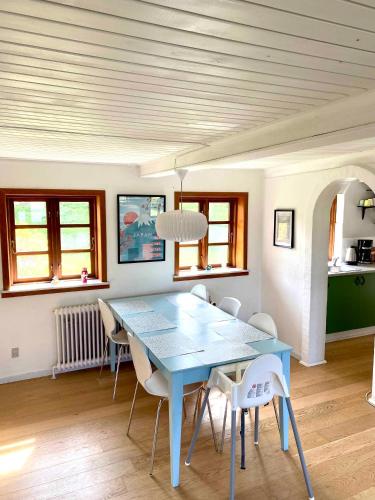 une salle à manger avec une table et des chaises bleues dans l'établissement Charming Cottage In The Best Hc Andersen Style, à Frørup