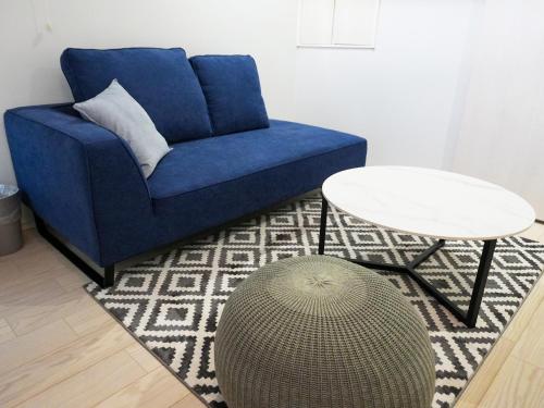 a blue couch and a table in a living room at OUCHI HOTEL Onaganishi in Hiroshima