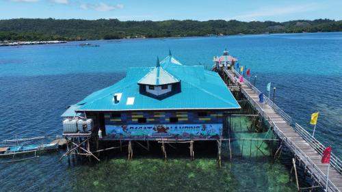 a house on a dock in the water at Enchanted River Rock Island Resort in Hinatuan