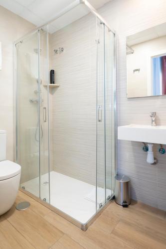 a glass shower in a bathroom with a sink at Hostal Pensimar in El Altet