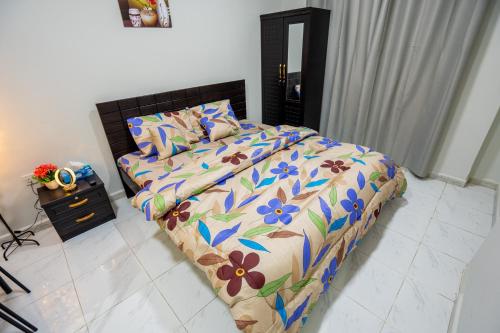 a bedroom with a bed with a floral comforter at Master bedroom apartment in Abu Dhabi