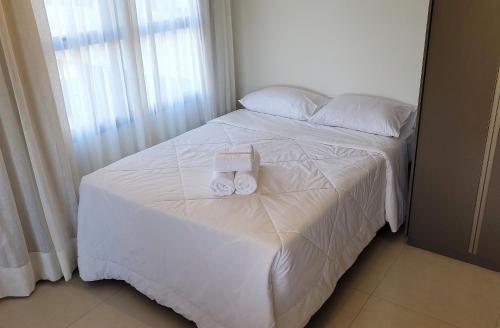 a bedroom with a white bed with two towels on it at Blend Coliving One - 2b in Ribeirão Preto