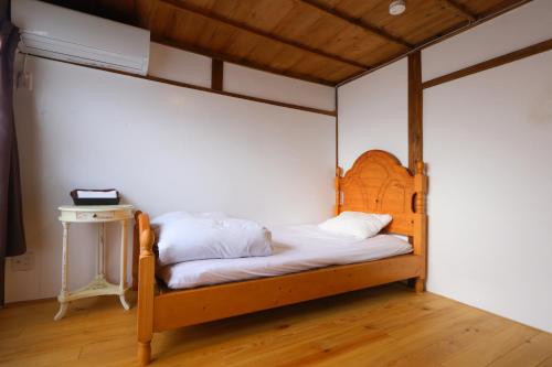 a bed with a wooden frame in a room at ホテル宿かいふ in Kaiyo