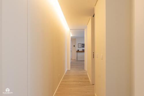 a hallway with white walls and wooden floors at Varanda do Guincho - Classy Apt in Santa Cruz in Silveira