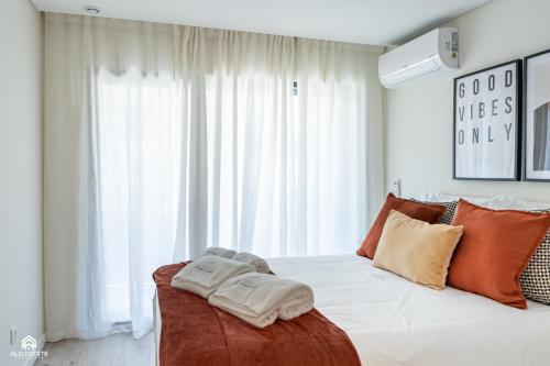 a bedroom with a bed with two towels on it at Varanda do Guincho - Classy Apt in Santa Cruz in Silveira