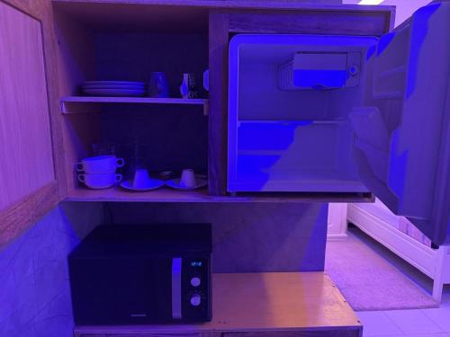 a kitchen with an open refrigerator with blue lights at Chambre Meulé A Mbour in Mbour