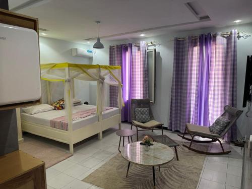 a bedroom with a bed and a table and chairs at Chambre Meulé A Mbour in Mbour