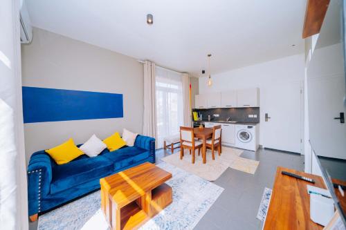 a living room with a blue couch and a table at 1 BDR Garden Apartment at The Soul, Paje in Paje