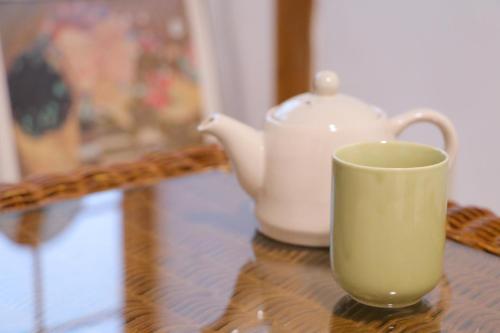 a tea kettle and a cup on a table at ホテル宿かいふ in Kaiyo