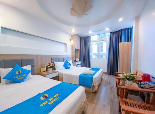 a hotel room with two beds and a table at Khách sạn Thế Kỷ Mới in Hanoi