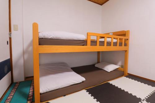 a room with three bunk beds in a room at ホテル宿かいふ in Kaiyo