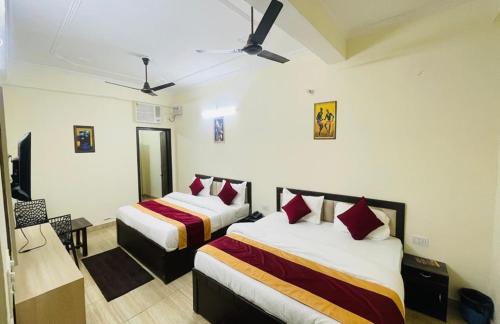 a hotel room with two beds with red pillows at The Gange Hill By Green Bird Hospitality in Rishīkesh