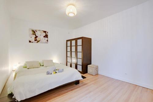 une chambre avec un grand lit dans une pièce blanche dans l'établissement Super Lilas cosy, aux Lilas