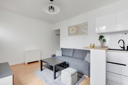 un salon avec un canapé et une table dans une cuisine dans l'établissement Super Lilas cosy, aux Lilas