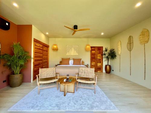 a bedroom with a bed and a table and chairs at Wild Cottages Elephant Sanctuary Resort in Amphoe Koh Samui