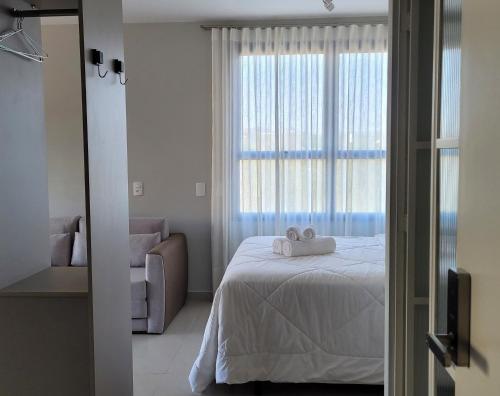 a bedroom with a bed with two towels on it at Blend Coliving One - 1 in Ribeirão Preto