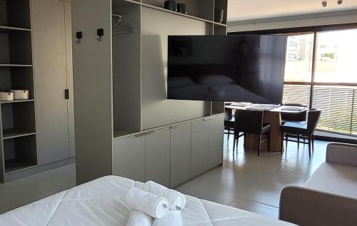 a room with a bed and a kitchen with a table at Blend Coliving One - 1 in Ribeirão Preto