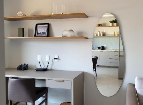 a living room with a table and a mirror at Blend Coliving One - 1 in Ribeirão Preto
