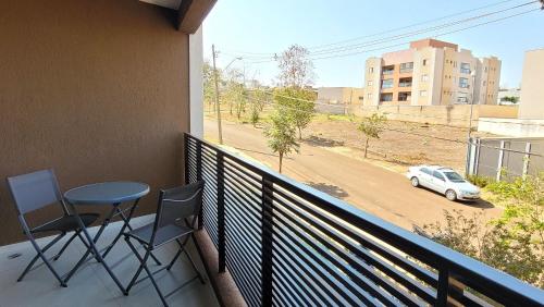 a balcony with a table and chairs and a car at Blend Coliving One - 1 in Ribeirão Preto