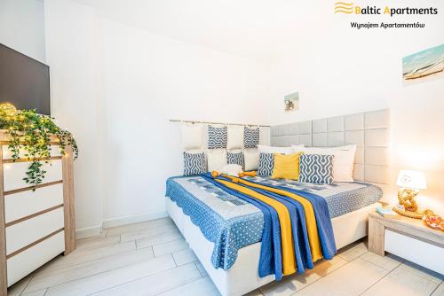 a bedroom with a bed and a dresser at Baltic Apartments - Apartamenty Aquamarina in Świnoujście