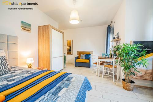 a bedroom with a bed and a dining room at Baltic Apartments - Apartamenty Aquamarina in Świnoujście