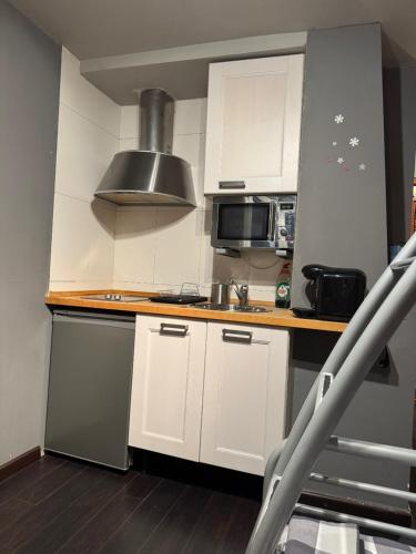 a kitchen with white cabinets and a stove top oven at Precioso apartamento en San Isidro , ski , snow in San Isidro