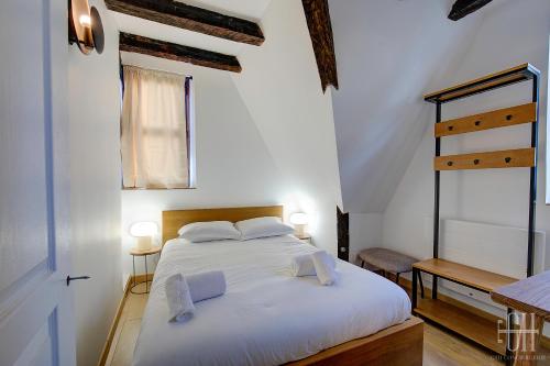 ein Schlafzimmer mit einem großen weißen Bett mit zwei Kissen in der Unterkunft Appartement avec 2 chambres, bureau et wifi fibre in Tours