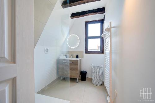 ein weißes Badezimmer mit Waschbecken und Fenster in der Unterkunft Appartement avec 2 chambres, bureau et wifi fibre in Tours