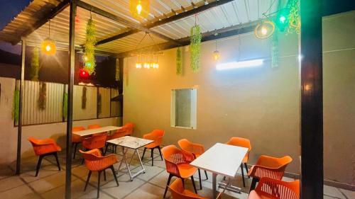 a restaurant with orange chairs and tables in a room at The Gange Hill By Green Bird Hospitality in Rishīkesh