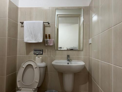 a bathroom with a toilet and a sink and a mirror at Beachfront U.S. Embassy Family Retreat. in Manila