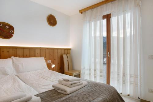 a bedroom with a bed with towels on it at Agritur Maso Flonkeri in Bosentino
