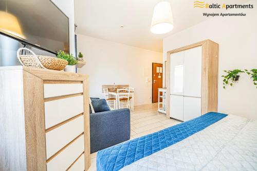 a bedroom with a bed and a living room at Baltic Apartments - Apartamenty Aquamarina in Świnoujście