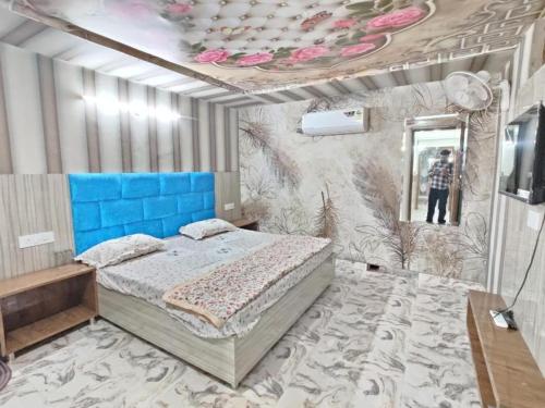a bedroom with a bed and a painting on the wall at TEJAS HOMESTAY JUST 2 MINUTES from GOLDEN TEMPLE in Amritsar