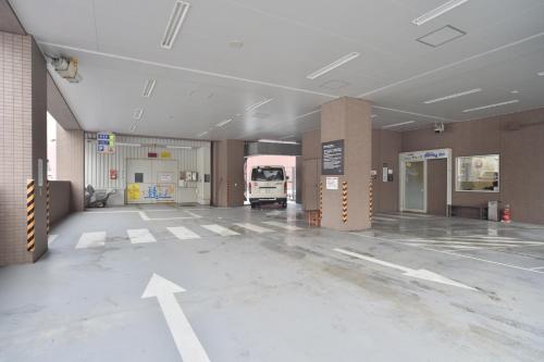 an empty parking lot with a white truck in a building at Dormy Inn Wakkanai in Wakkanai