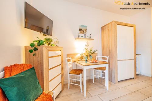 a living room with a table and a dining room at Baltic Apartments - Apartamenty Aquamarina in Świnoujście