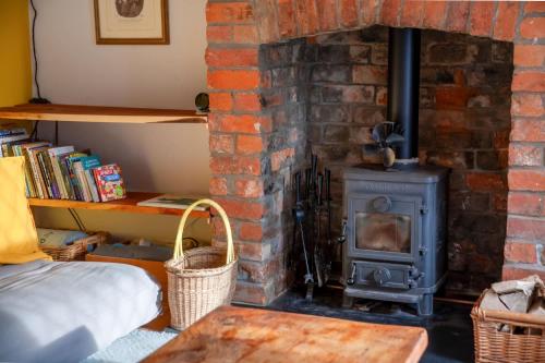 ein gemauerter Kamin mit Ofen in einem Zimmer in der Unterkunft Cosy Cottage nr The Cotswolds Private Parking in Charfield