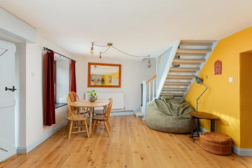 ein Esszimmer mit Tisch und Treppe in der Unterkunft Cosy Cottage nr The Cotswolds Private Parking in Charfield