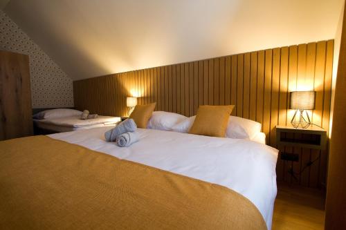 a bedroom with a large white bed with two pillows at CHALETY MÝTO POD ĎUMBIEROM in Mýto pod Ďumbierom