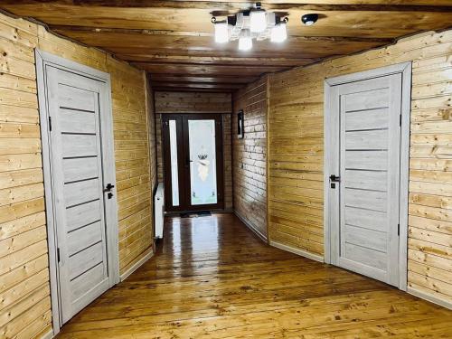 two doors in a room with wooden walls at Готель-кафе Чатина in Soymy