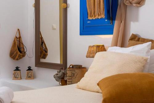 a bedroom with a bed with a mirror on the wall at Blue Meadow in Livadi Astypalaias