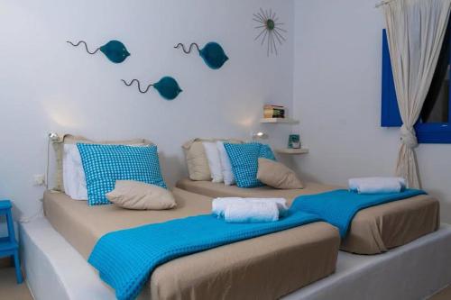 two beds in a room with blue pillows at Blue Meadow in Livadi Astypalaias