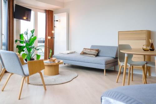 a living room with a couch and a table at Hotel du Bassin in Ostend